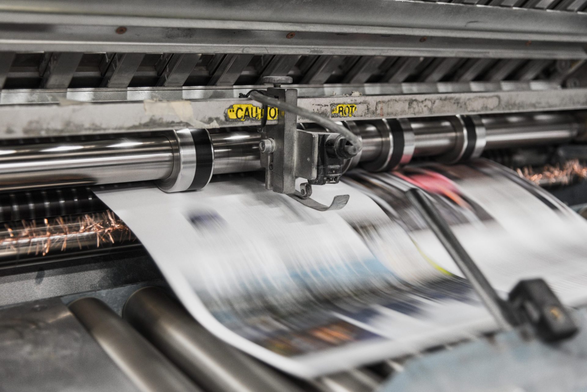 Copies of newspaper coming out of printing press