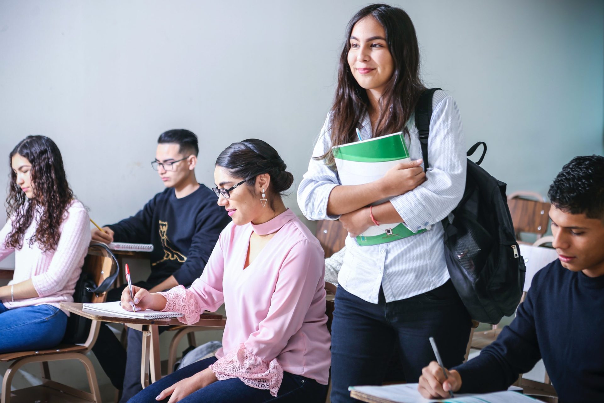 Woman student standing in classroom with other students